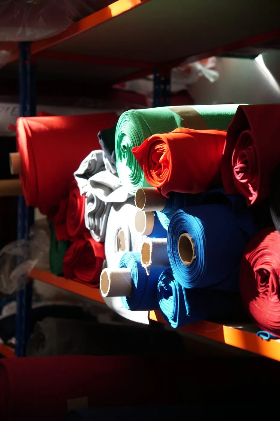 Rolls of knit fabric on shelves in the fabric store